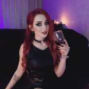 Dominatrix master with a glass cup of exotic red wine